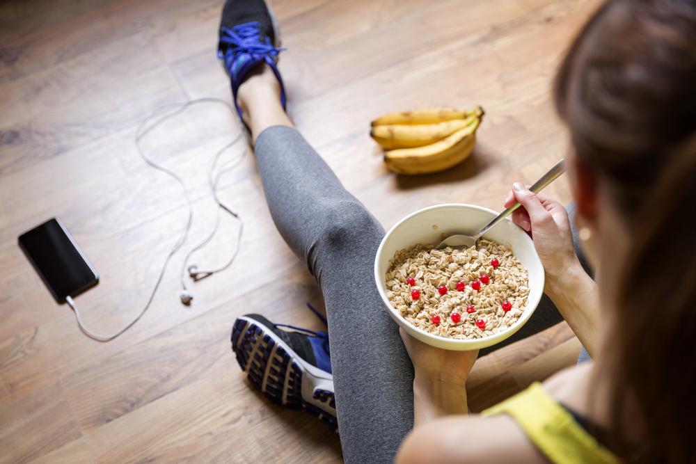 žena jí kaši po sportovním výkonu