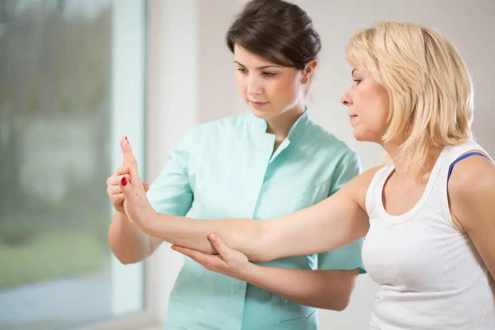 fyzioterapeut cvičí s rukou ženy s karpálním tunelem