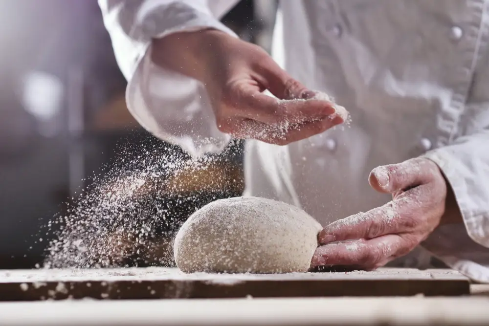 pekař zadělává těsto na chléb