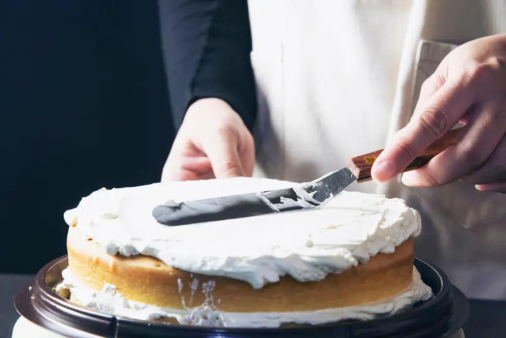 Žena promazává dort krémem