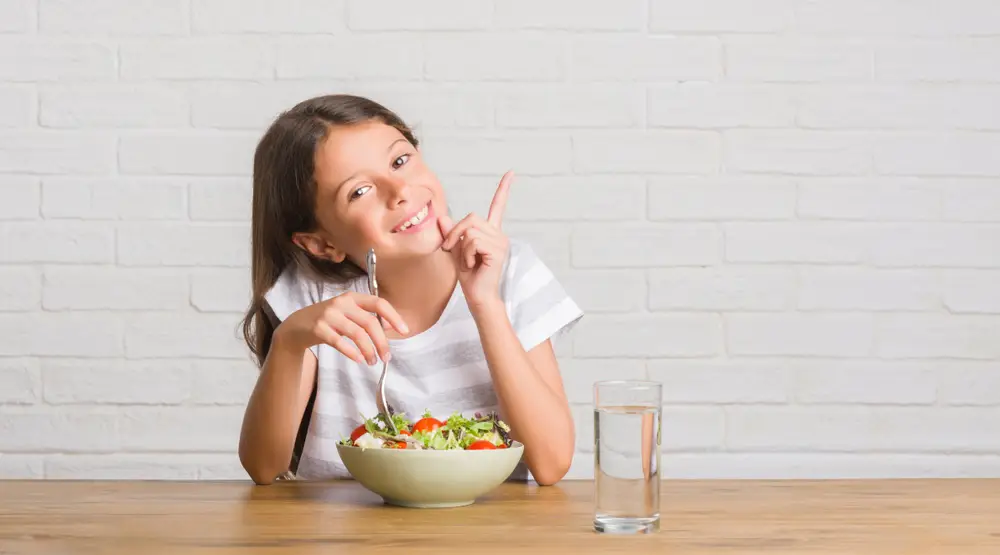 dívka jí zeleninový salát