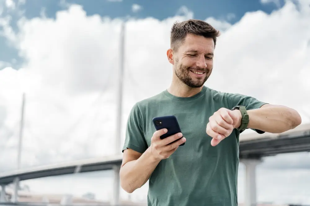 sportující muž kontrolující chytré hodinky