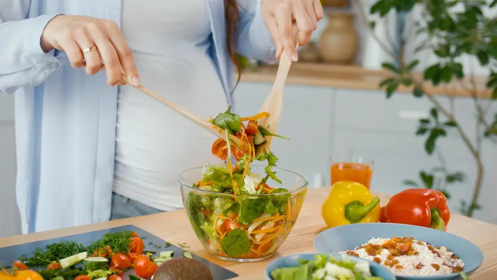 těhotná žena připravující si zdravý salát