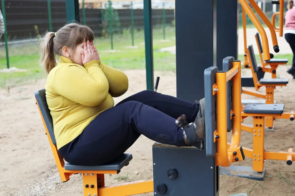 smutná obézní dívka ve venkovní posilovně